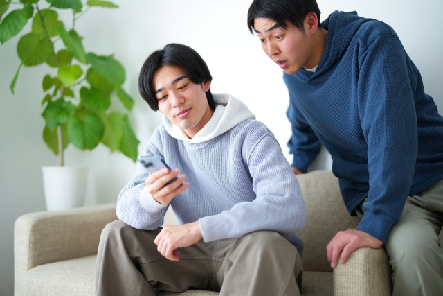 スマホを観る男性2人