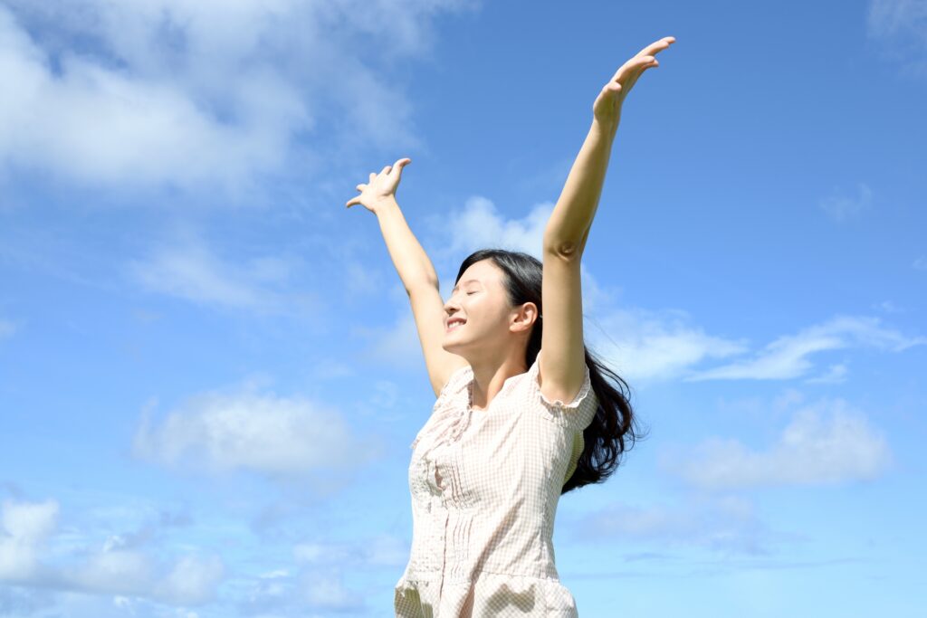手を上に伸ばす女性