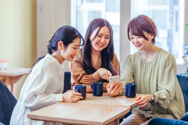 カフェでスマホを観る若い女性